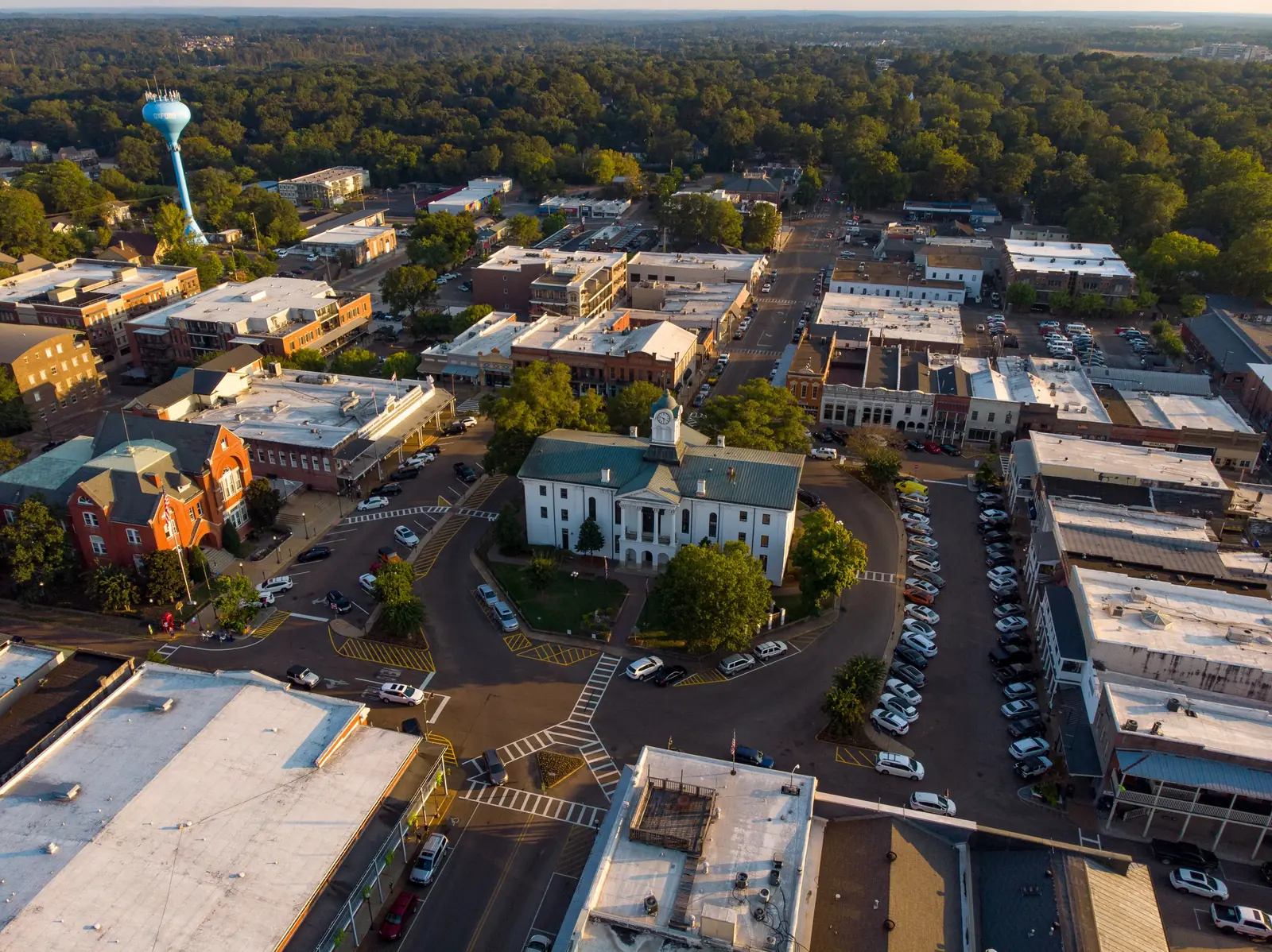 The Lafayette County Courthouse and the Square in downtown Oxford, seen from above, with a city water tower on the skyline.